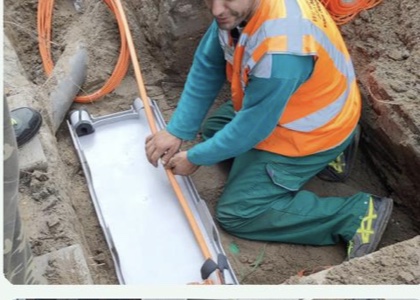 Technician guiding fiber duct installation